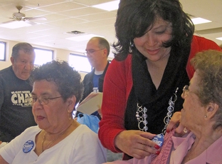 Norma Chavez works attaches a campaign button to the sweater of one of her supporters at an El Paso senior center before the 2010 Democratic primary election.