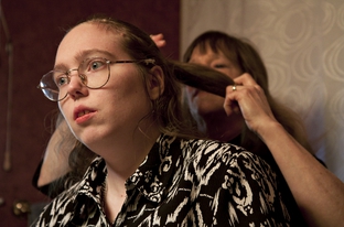 Barbara Cullison does her daughter Audrey's hair. Audrey, who is autistic, risks losing her Medicaid waiver services because of state budget cuts.