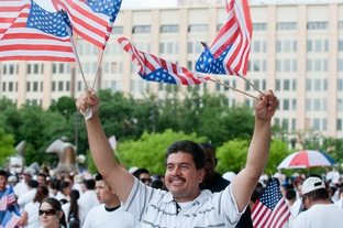 Demonstrator Jesus Sandovar waves four American flags at an immigration rally in Dallas.