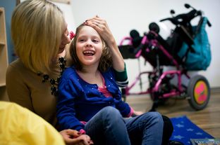 Laura Romero plays with her daughter Brooklyn, who has Cerebral Palsy, during the open house and tour of Seton's new Children's Comprehensive Care Clinic in Austin, Texas.