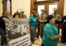 Department of Public Safety troopers guard the governor's office on April 1, 2013, as a group protests Republicans' stance on Medicaid expansion.