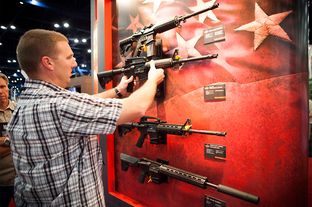 A man who declined to be identified looks at Bushmaster rifles at the NRA's national convention in Houston, Friday May 3, 2013.