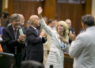 Sen. Wendy Davis, D-Ft. Worth, waves to the gallery while leaving the Senate chamber after midnight on June 26, 2013.