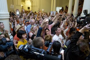 Protesters outside the Texas Senate chamber cheer as Sen. Wendy Davis leaves on June 26, 2013.