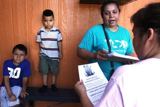 Zoila Chaver, second from right, a member of the Texas Organizing Project, giving health care information to Dallas resident Graciela Garcia at Garcia's home on July 10, 2013.