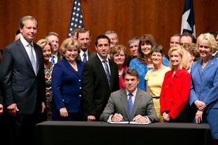 Gov. Rick Perry, surrounded by Republican lawmakers, signs House Bill 2 into law on July 18, 2013.