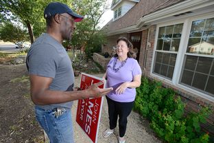 Mayoral candidate John James talks with Sarana Savage outside her Midland home on Sept. 15, 2013.
