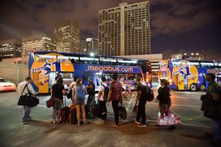 Passengers wait in line to board the Megabus to Austin at the Houston bus stop located at 815 Pierce St. on Sept. 27, 2013.