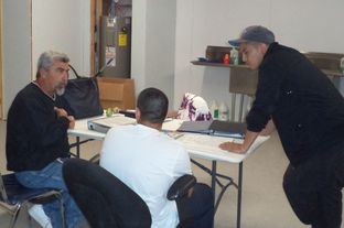 Bruce Ballou, left, and Jose Luis Perez tutor a teenager participating in the alternative education program in Maverick County.