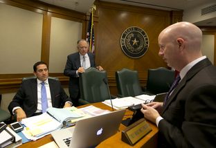 Rep. Trey Martinez Fischer, D-San Antonio, and Rep. Dan Flynn, R-Canton, speak with a lawyer during a break at a House Committee on Transparency in State Agency Operations hearing on October 23rd, 2013