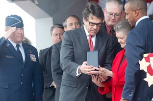 Governor Rick Perry and state representative Scott Turner, right, present Nadine Murphy, sister of the late Audie Murphy, with the posthumous Texas Legislative Medal of Honor for her brother in Farmersville on Tuesday, Oct. 29, 2013.