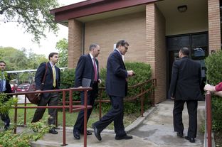 Aides follow Gov. Rick Perry into a West Austin early voting station on Oct. 30, 2013.