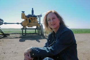 DeDe Cummins sits next to an irrigation well at her farm in the Texas Panhandle.