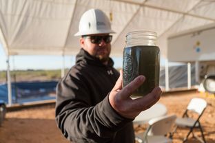 Jonathan Jones, Field Supervisor for Water Rescue Services, holding partially cleaned fracking waste water.