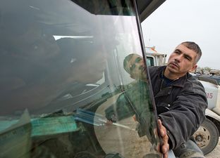 Eddie Posselt (right) works on a 18 Wheeler tanker truck's windshield with his employee Danilo Estaco (inside truck) on Dec. 12, 2013. Posselt moved to Carrizo Springs last year to work in the oil fields, ended up launching Windshields Etc in July. He now runs the business full time. The oil drilling boom in South Texas' Eagle Ford Shale has also led to a boom in windshield repair and replacement.