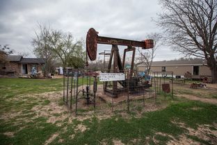 Most of the 183 pump jacks scattered throughout Luling are unadorned, such as this one in the middle a shared yard.