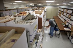 Daniel Ortuño, who manages the 1.5 million drilling records stored at the University of Texas at Austin's Bureau of Economic Geology, examines well data in what he calls the "spooky room," home to thousands of records that he has not yet organized. State water researchers are using information from some logs to map potential water sources.