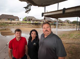 Granbury resident Joe Williams (left) stands with City Council Member Rose Myers and Hood County Commissioner Steve Berry under a Lake Granbury resident's dock in the Waters Edge neighborhood on Lake Granbury's north shore. The lake is 53 percent full.