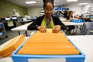Ballot-by-mail clerk Chaundra Grattan organizes ballot packages at the Travis County Elections Division in Austin on May 19, 2014.