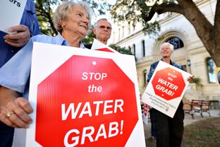 Lee County resident Hilde Sides protests the Vista Ridge Water Supply Project with other Lee and Bastrop County residents outside the San Antonio City Council public hearing on the project on Oct. 8, 2014.