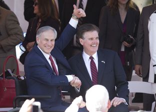 Newly sworn in, Gov. Greg Abbott and Lt. Gov. Dan Patrick watch the inaugural parade up Congress Avenue in Austin, Texas on January 20, 2015.