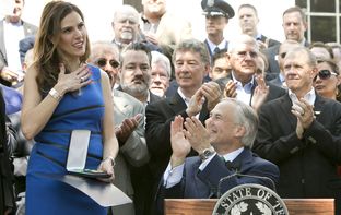Taya Kyle receives the Texas Legislative Medal of Honor that Gov. Greg Abbott awarded to her late husband, Chris Kyle, on Aug. 26, 2015.