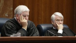 Texas Supreme Court Justices Paul Green, left, and Chief Justice Nathan Hecht listen to oral arguments Sept. 1 in Texas' appeal of a 2014 ruling that struck down its system of funding public schools as unconstitutional.
