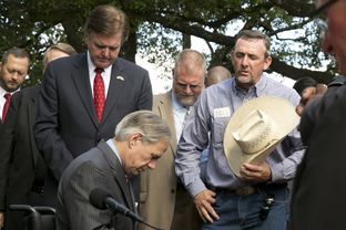 Jason Taylor from the Barnone Cowboy Church prays after Gov. Greg Abbott signed Senate Bill 2065, the Pastor Protection Bill on June 11, 2015