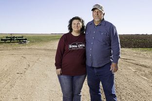 Hugh and Nancy Raney in front of a pair of fields, one currently fallow, on their farm near Big Spring. The couple had to stop farming part of their land when running the electric pumps to get well water to the fields became too expensive.