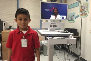 Second grader Diego Montealvo visits the school nurse’s office for a virtual checkup with Dr. Stormee Williams, a pediatrician with Children’s Medical Center of Dallas.