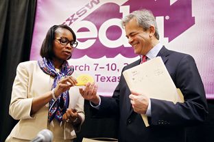 Mayor of San Antonio Ivy Taylor gifts the mayor of Austin Steve Adler a taco stress toy at the conclusion of the Taco Summit held at the Hilton Austin on March 10, 2016.