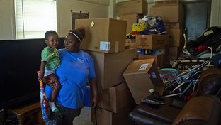 D.N. Leathers Public Housing Complex resident Jasmine Mosley holds her son De' Monei Traylor, 2 in their apartment on September 8, 2016