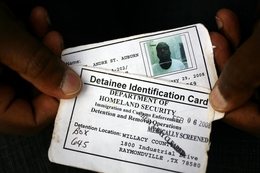 A detainee with mental health problems shows his ID card, which says he's been medically screened. 