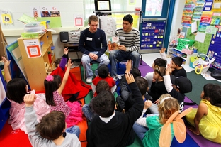 National Honor students Zach Calkins and Aaron Gonzales, seniors at Brandeis High School, read to kindergarten students in a crowded classroom at Wanke Elementary School in San Antonio on March 9, 2012.