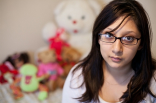Crystal Martinez sits with items recovered from Child Protective Services at her home in North Austin, Dec. 21, 2010.