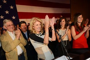 Wendy Davis, flanked by her father, Jerry Russell at left and her two daughters, at right, applauds her supporters during her victory speech at the Fort Worth Hilton on November 6, 2012.