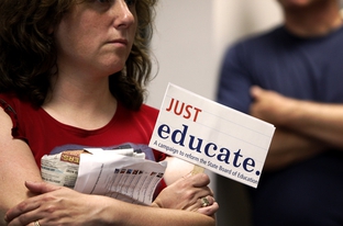 An observer holds a protest sign during testimony at the State Board of Education (SBOE) textbook hearings on Wednesday, May 19, 2010.