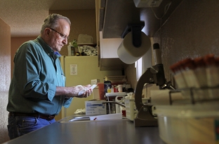 Dr. Roberto Margo cleans his hands after attending to a canine patient. As a result of his large animal work, Margo has had back, shoulder, and arm surgery.