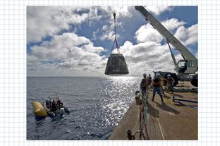 A crane lifts SpaceX's Dragon spacecraft on to a barge after the vehicle twice orbited the Earth in December of 2010.