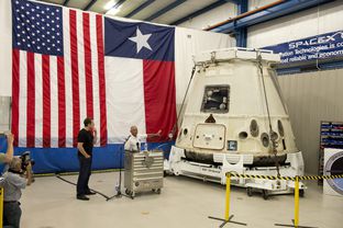 NASA administrator Charles Bolden, right, shows off the Dragon spacecraft as SpaceX CEO Elon Musk, left, listens in McGregor, TX on June 13, 2012.