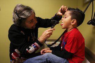 Dr. Sarah Helfand exams a patient during his checkup at Kessler Pediatrics in Dallas.