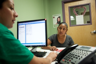 Nancy Sebrian, a patient service representative at The People's Community Clinic helps Angelina Chavez fill out paperwork. The Community Health Assistance Program, a program that helps Texans get access to insurance, will run out of federal grant money in a few weeks.