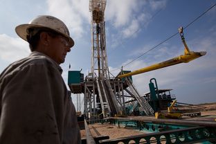 A worker waits to load a piece of pipe, or casing, that will be lowered into the well at a Chesapeake Energy drill site in Dimmit County, Texas in the Eagle Ford Shale.