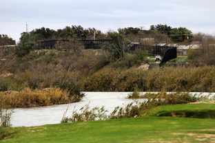 The Rio Grande and a towering border fence separate Eagle Pass, Texas from Piedras Negras, Mexico, Saturday, February 4, 2012.