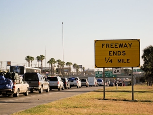 Thousands of motorists wait in line on the southernmost stretch of IH-35 in Laredo, Texas. Despite a global recession and escalating violence in Mexico thousands of "paisanos" still made the trek south for Christmas. As the hours passed, however, their concerns about traveling Mexico's highways at night grew. A recent prison break in Nuevo Laredo didn't help soothe their fears about bandits lurking on the roadways. "We might have to get a hotel here," said one traveler.