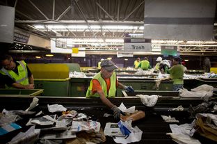 A Greenstar Recycling Center employee removes plastic bags from a sort line in Garland, Texas, September 13, 2012.