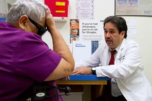 Dr. Javier Saenz with a patient, Elena Chavez, 73. Chavez is part of the 50 percent of patients Saenz sees who draw from both Medicare and Medicaid.