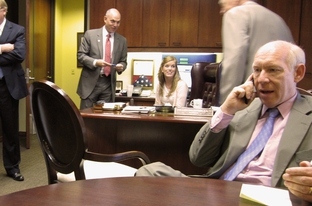 Bill White, on the phone in Grand Prairie Mayor Charles England's office. Behind him, from left to right, are Rep. Kirk England, son of the mayor, Theresa Woodward, his chief of staff, and the mayor himself.