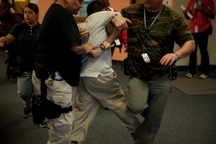A detainee is removed from the school building after an outburst during class.