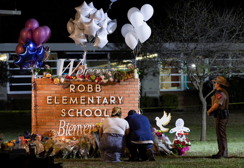 Stephanie and Michael Chavez of San Antonio pay their respects at a makeshift memorial outside Robb Elementary School on Wednesday. (REUTERS/Nuri Vallbona)